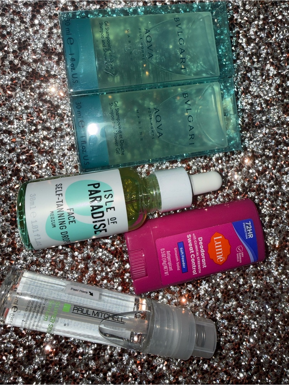 Isle of paradise face self tanning drops and travel size hair and body care lot.